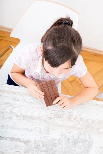 Daughter eating chocolate at home — Stock Photo, Image